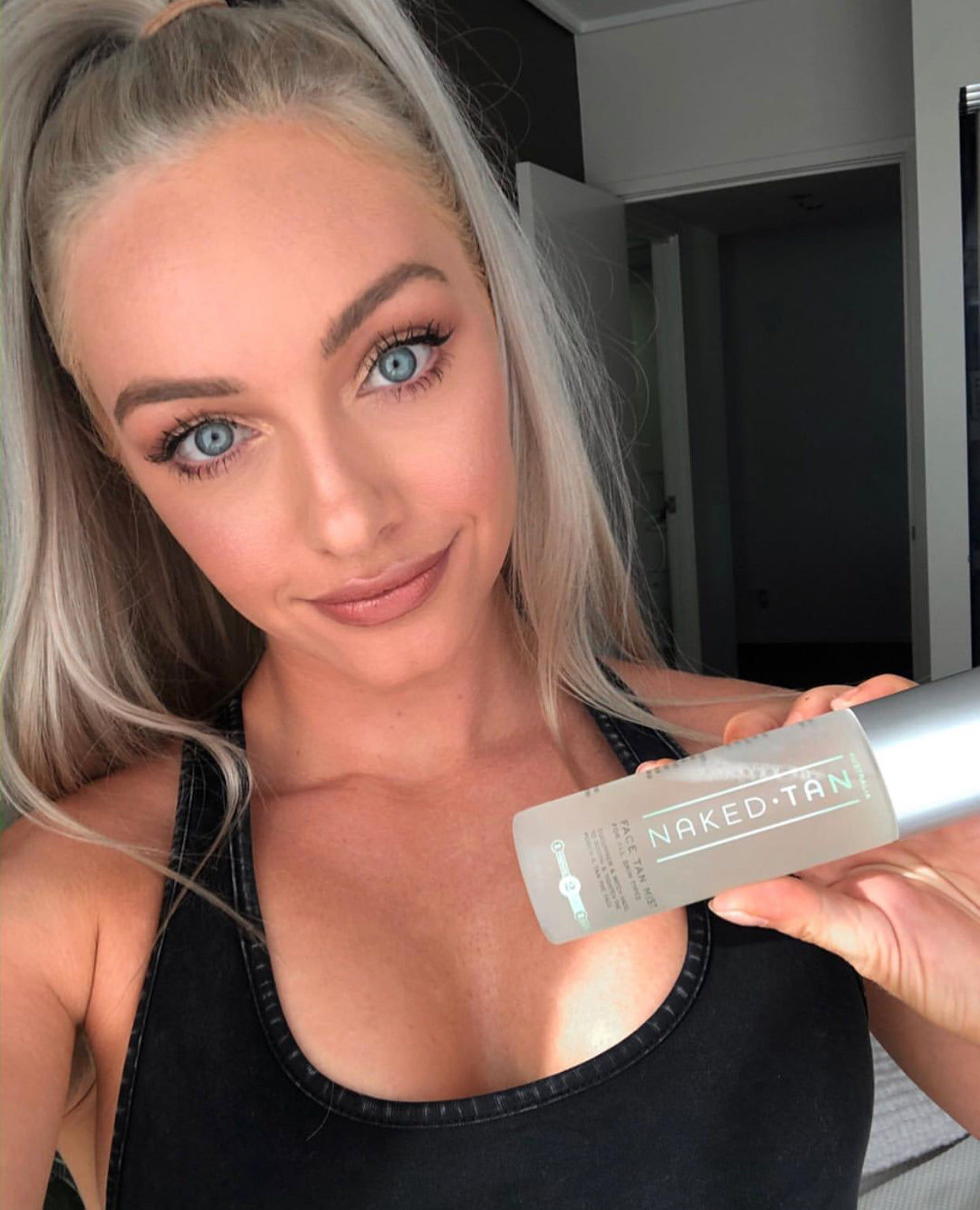 Blonde girl holding Naked Tan Face Tan Mist